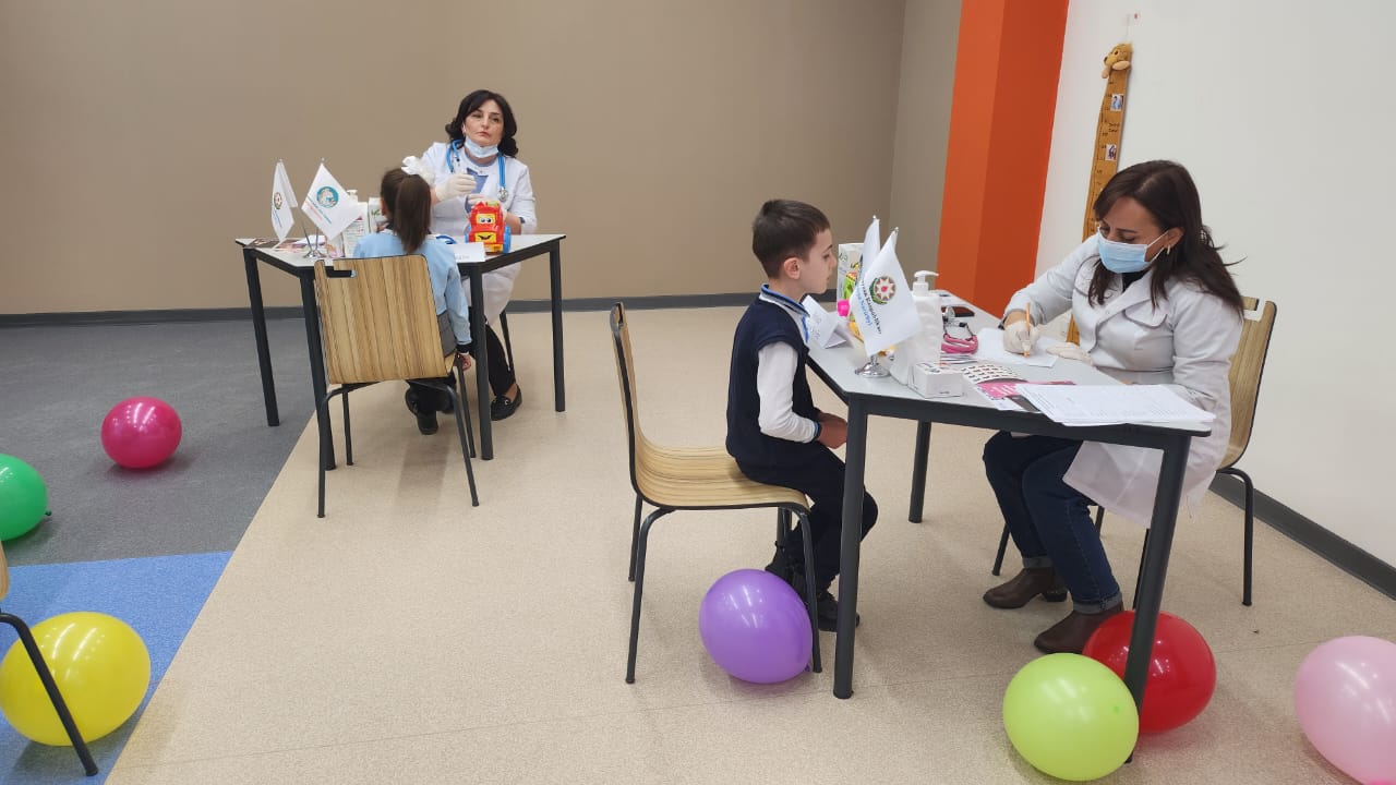 a group of people sitting at a table with balloons