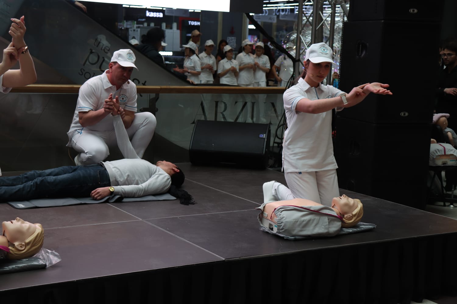 a person in white shirt and cap standing in front of a person lying on the ground with the