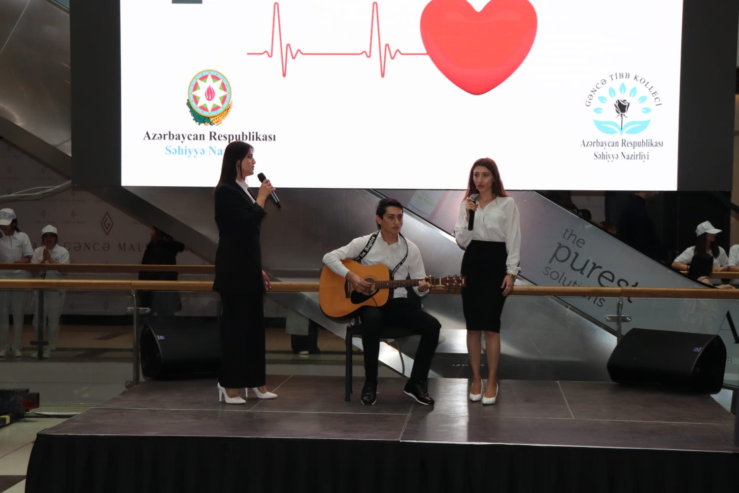 a man and a woman on a stage with a guitar