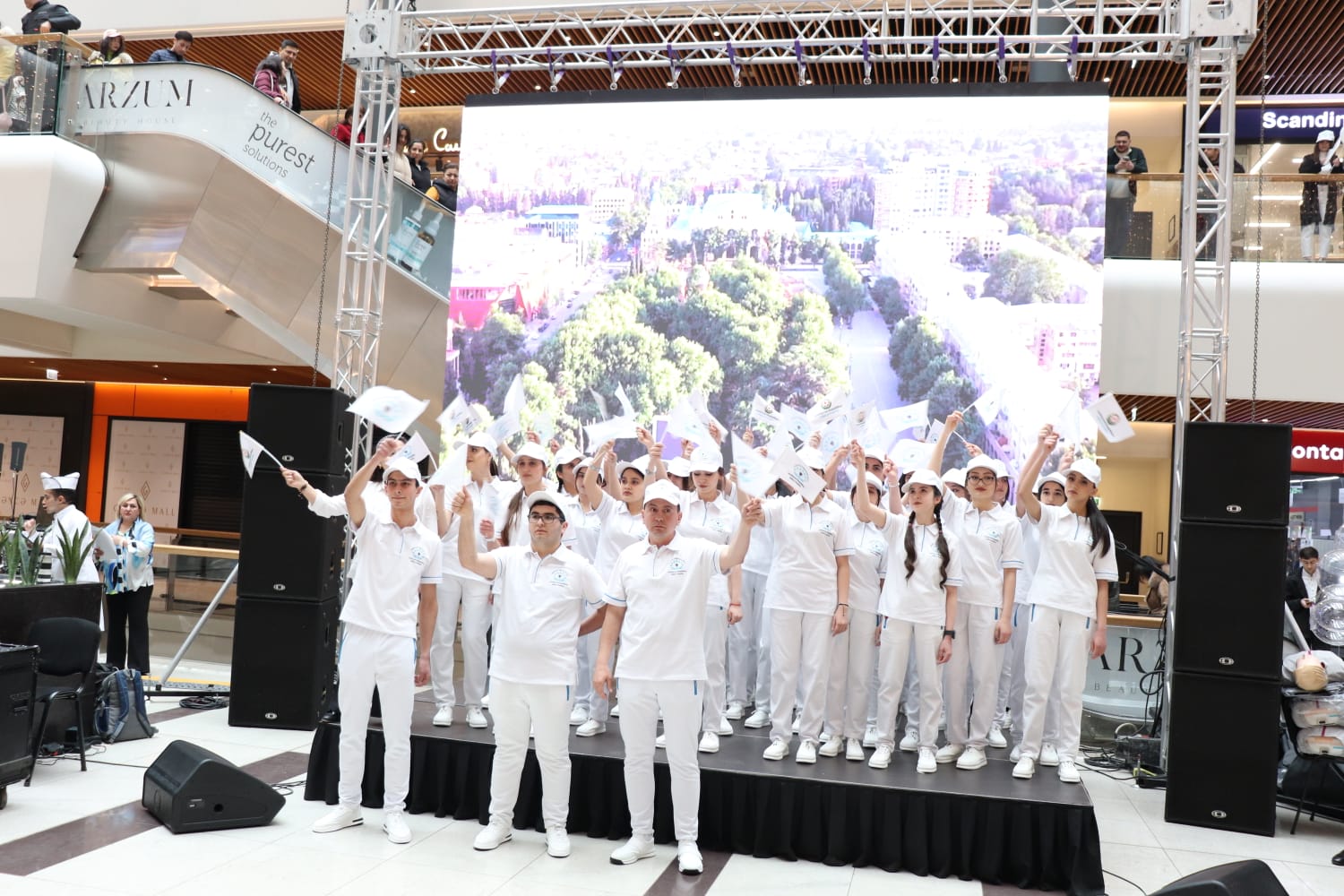 a group of people in white outfits on a stage