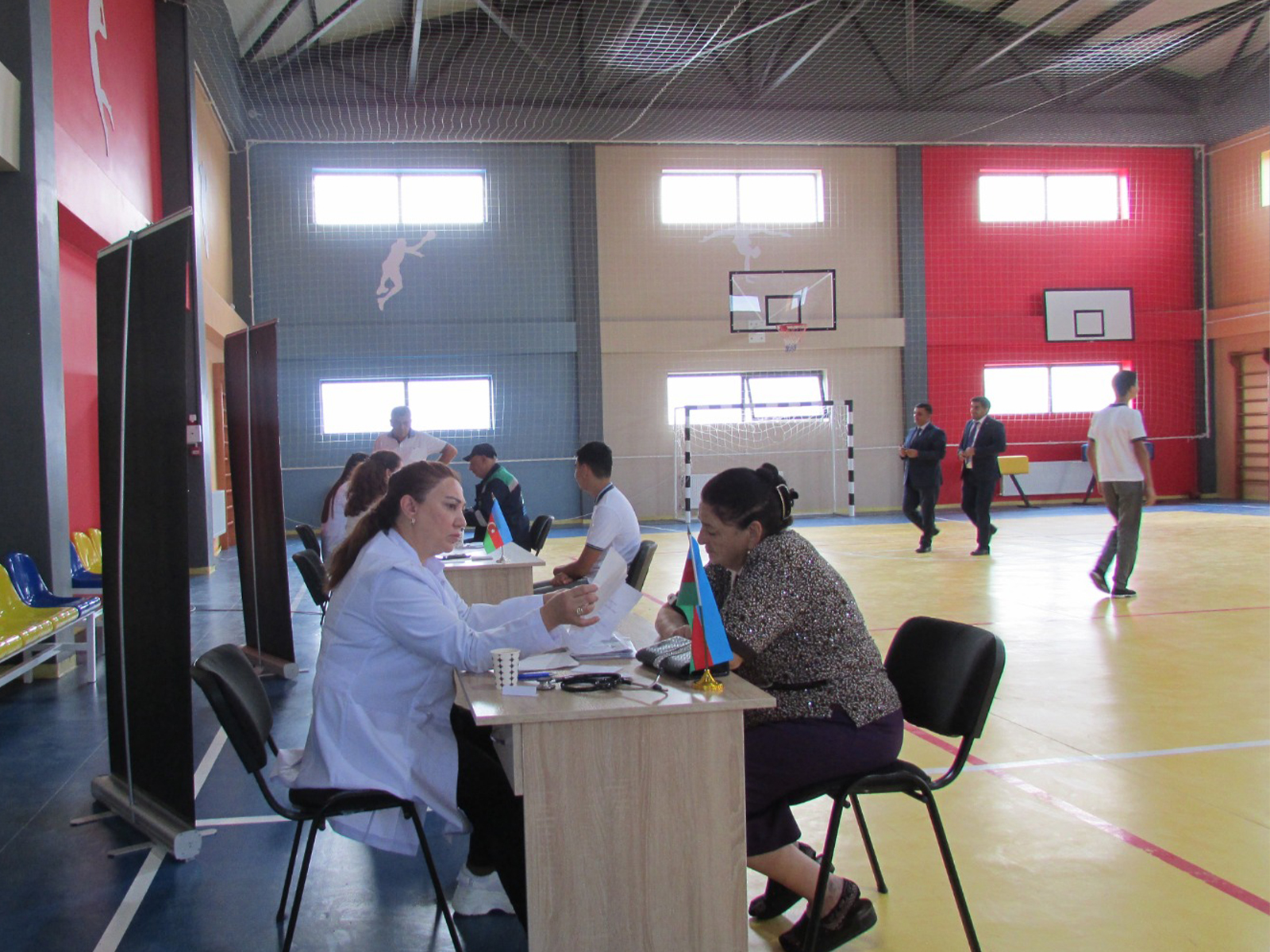 a group of people sitting at a table in a room with a screen