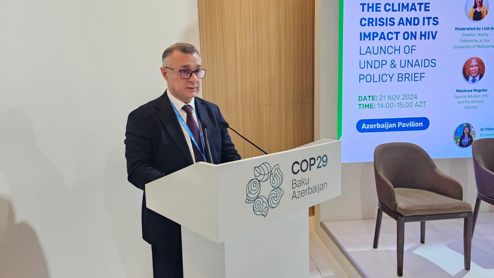 A speaker at a podium discusses the climate crisis and its impact on HIV at COP29 in Baku, Azerbaijan.