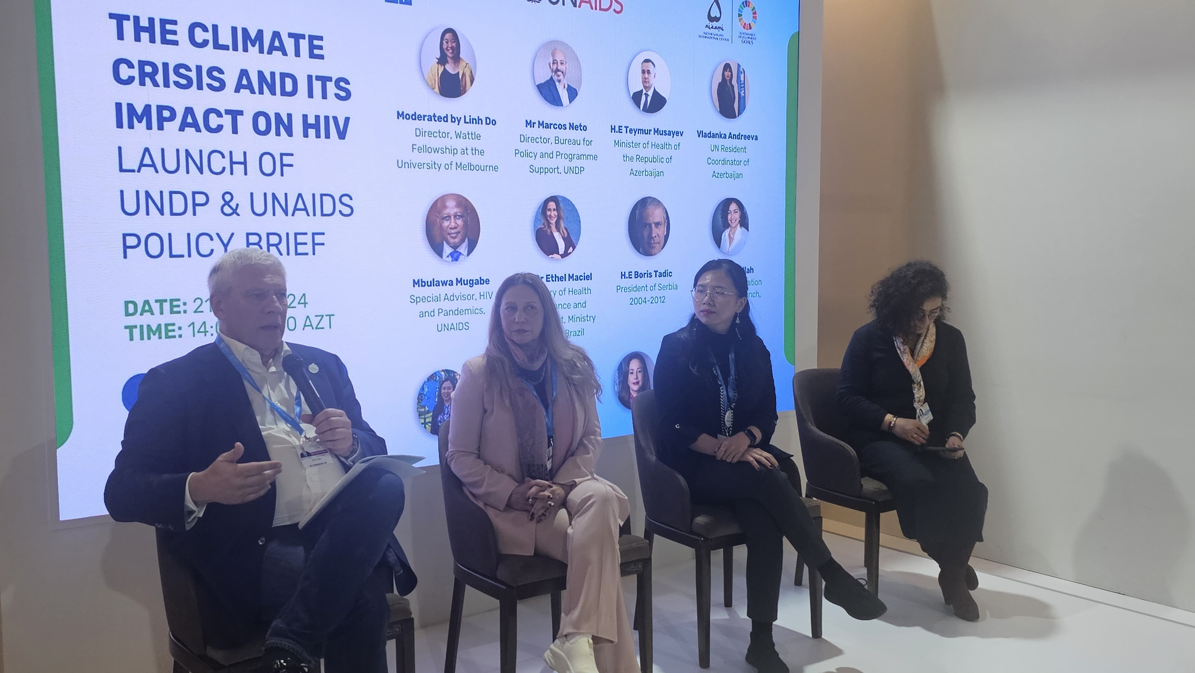 A panel discussion on the climate crisis and its impact on HIV, featuring multiple speakers and a presentation backdrop.