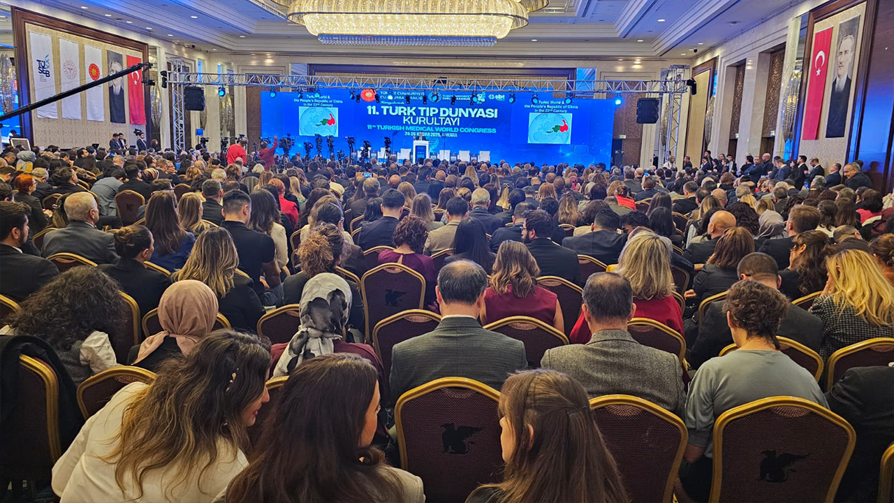 A large audience is seated in a conference hall, facing a stage with a screen displaying "11th Turkish Medical World Congress."