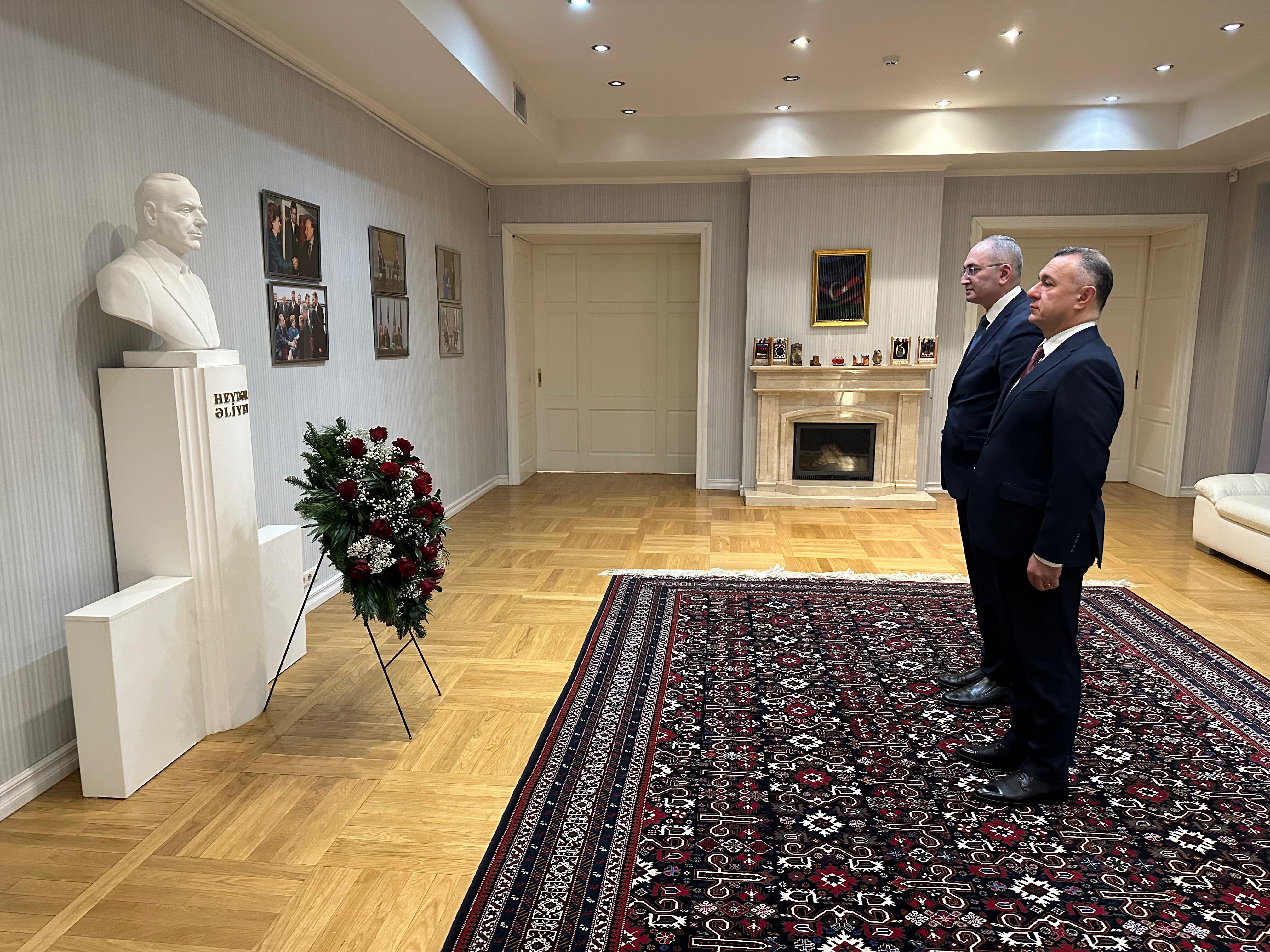 a man and a woman standing in a room with a statue